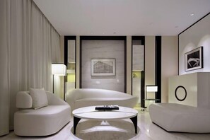 A modern living room with a sofa, a coffee table, and a framed picture on the wall. - Ziyuan Hotel (Wuhan)