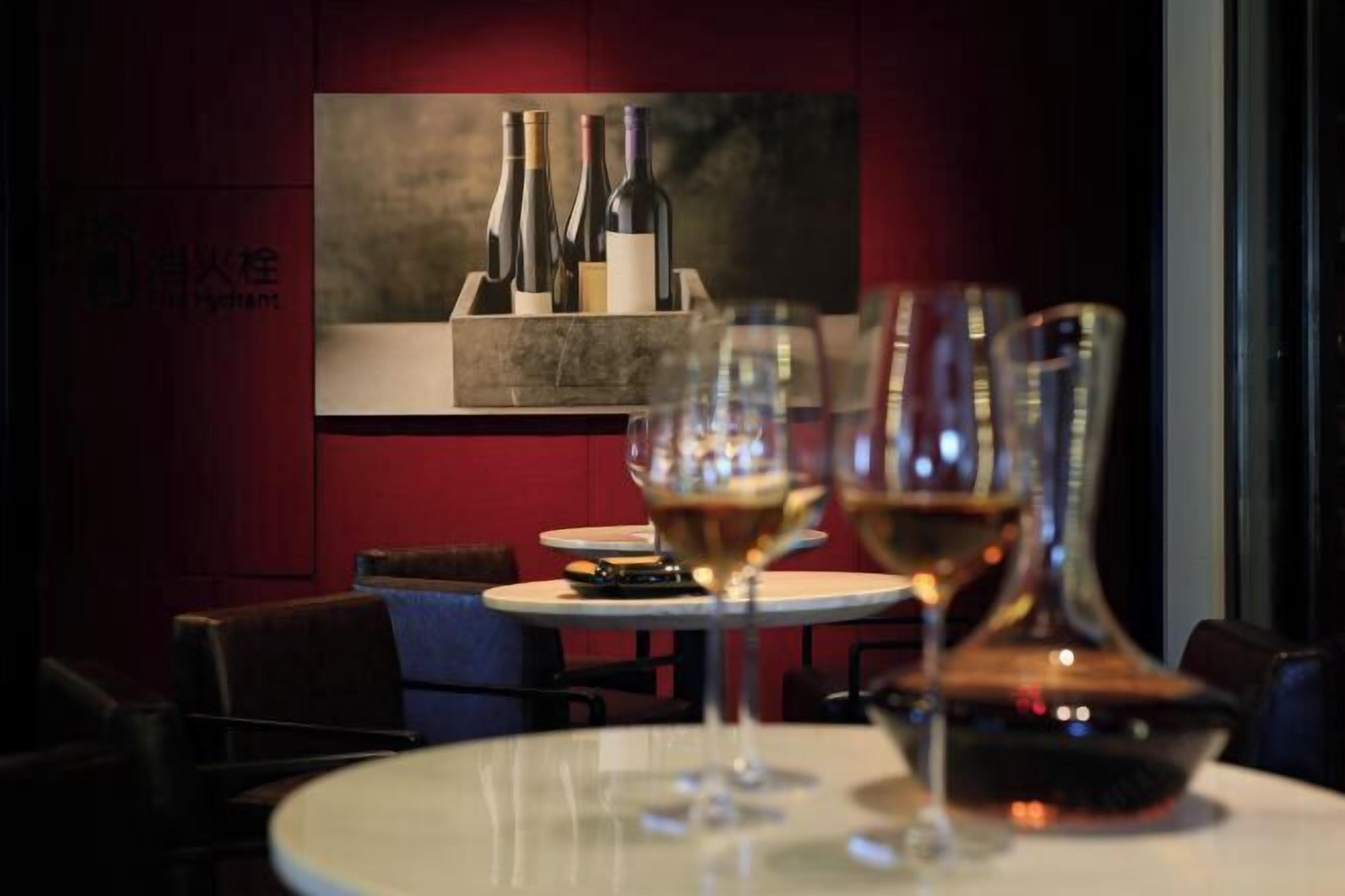 Interior de un restaurante con una vitrina de vinos y mesas de comedor.