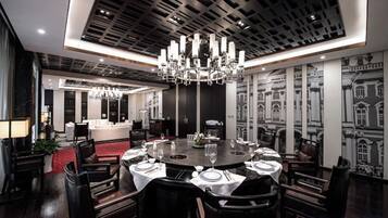 A modern dining area with a round table set for six, surrounded by dark wooden chairs.