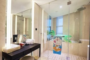 A modern bathroom with a glass shower enclosure, a vanity with a mirror, and a toilet visible through the glass.