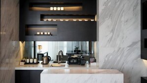 Una cucina moderna con un piano di lavoro in marmo, elettrodomestici integrati e illuminazione a incasso.