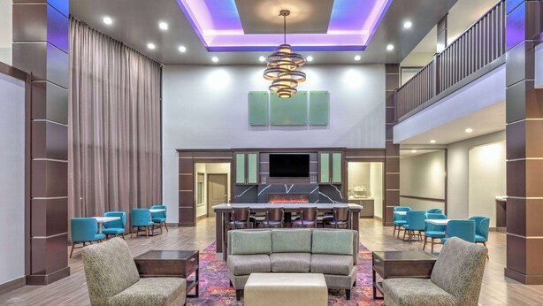 A spacious lobby with a central seating area, a flat-screen TV, and a fireplace. - La Quinta Inn & Suites by Wyndham Tyler - University Area (Tyler)