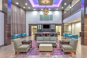 A spacious lobby with a central seating area, a flat-screen TV, and a fireplace. - La Quinta Inn & Suites by Wyndham Tyler - University Area (Tyler)