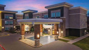 A modern building with a covered entrance, stone pillars, and a parking area. - La Quinta Inn & Suites by Wyndham Tyler - University Area (Tyler)