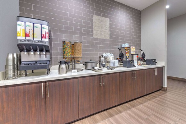 A modern kitchen area with a coffee station, a waffle maker, and various kitchen appliances. - La Quinta Inn & Suites by Wyndham Tyler - University Area (Tyler)