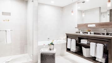 A modern bathroom with a glass-enclosed shower, a wooden vanity with a mirror, and a built-in bathtub.