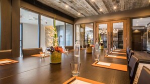 A conference room with a long table, chairs, and glassware.