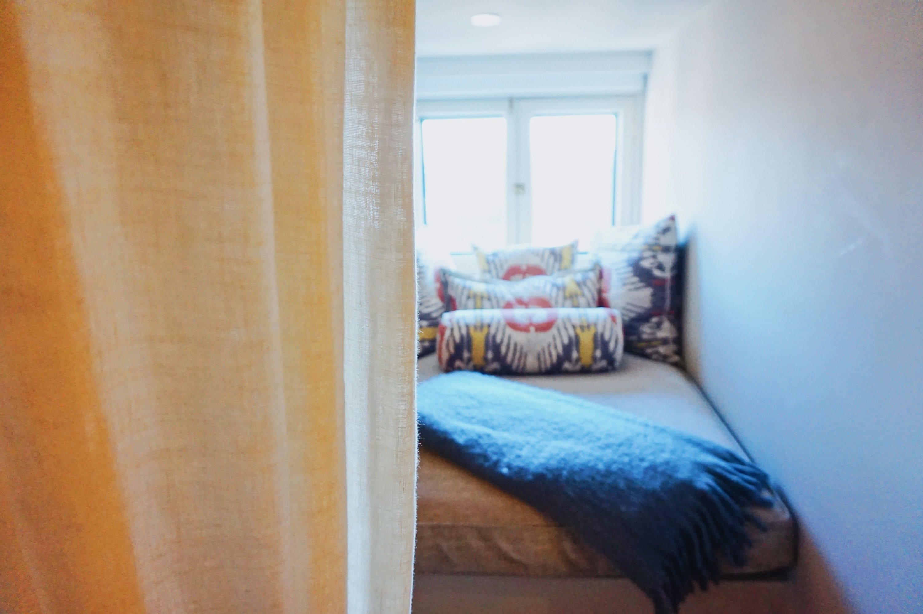 A bedroom with a bed, pillows, and a window.