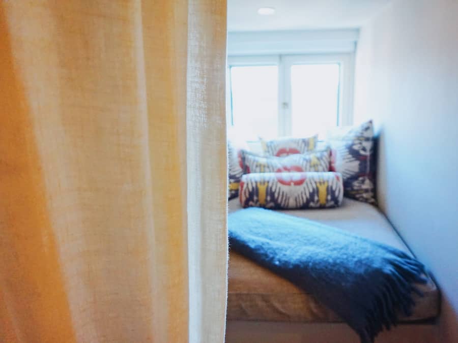 A bedroom with a bed, pillows, and a window.