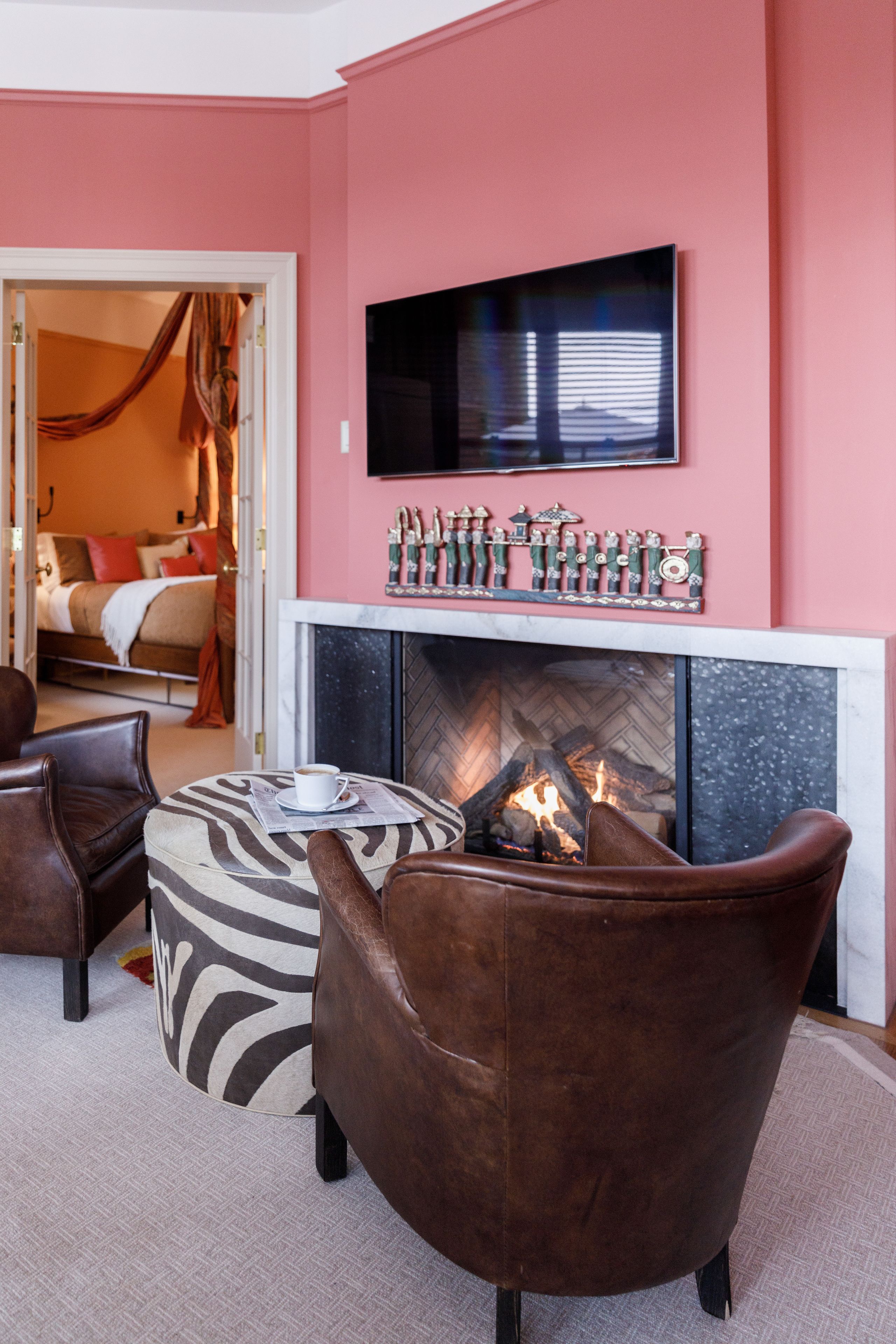Una sala de estar acogedora con chimenea, sillones de cuero y un televisor de pantalla plana.