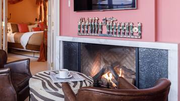 Una sala de estar acogedora con chimenea, sillones de cuero y un televisor de pantalla plana.