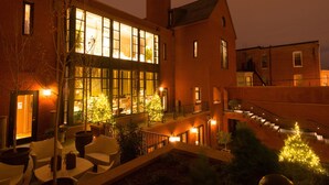 A building with large windows, outdoor seating, and a staircase. - The Ivy Hotel (Baltimore)