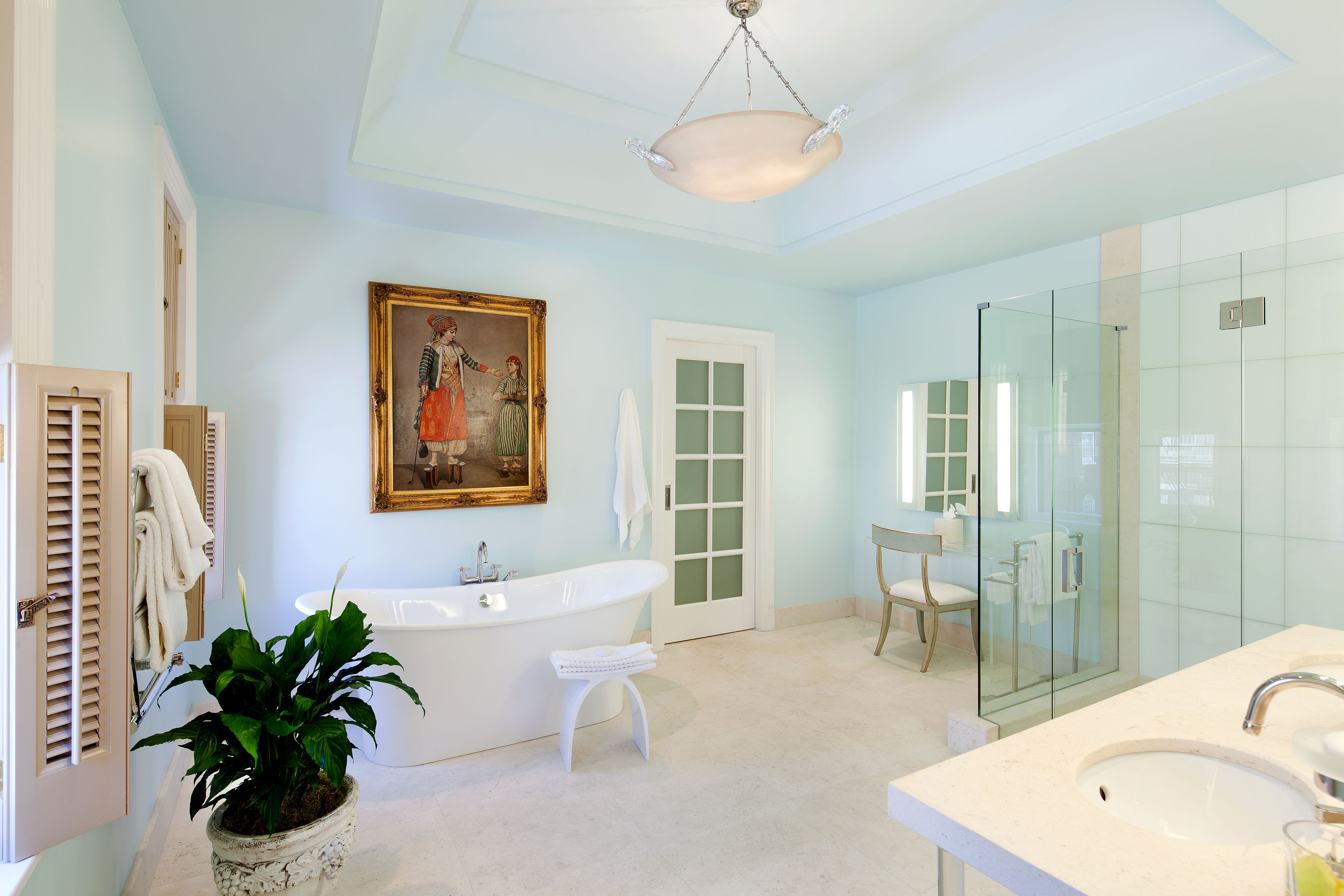 Un baño moderno con una bañera independiente, ducha con cerramiento de vidrio y un espejo grande.