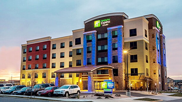 Holiday Inn Express & Suites -hotelli, jossa on pysäköintialue hotellin edessä.