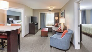 Ein Hotelzimmer mit Bett, Schreibtisch, Stuhl, Fernseher und Lampe.