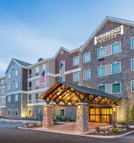 Un hotel Staybridge Suites con fachada de ladrillo, varias ventanas y entrada cubierta.