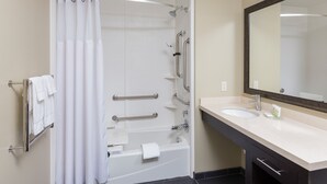 Ein modernes Badezimmer mit Badewanne, Waschbecken und großem Spiegel.