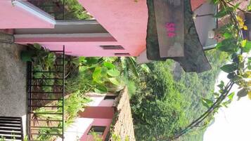 Edifício rosa com portão de metal e uma placa.
