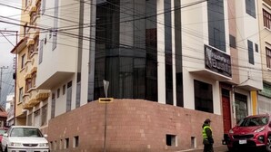 A multi-story building with a modern architectural design, featuring a curved facade and large windows. - Hostelling Bustillo (Sucre)