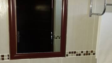 A bathroom with a white sink, a mirror with a wooden frame, and a towel rack.