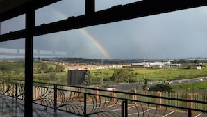 A view of a cityscape with a rainbow, buildings, and a road. - Eagle Nest Luxury Accommodation (Roodepoort)