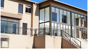 A modern building with large windows and a staircase leading to an upper level. - Eagle Nest Luxury Accommodation (Roodepoort)