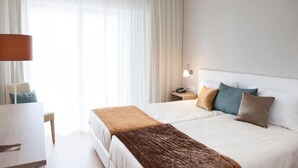 A hotel room with a bed, a desk, and a lamp. - Flag Hotel Aljustrel (Aljustrel)