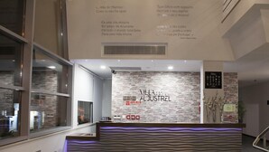 A hotel reception area with a stone wall and a modern reception desk. - Flag Hotel Aljustrel (Aljustrel)