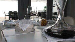 A dining table set with wine glasses, a decanter, and a small jar of jam. - Flag Hotel Aljustrel (Aljustrel)