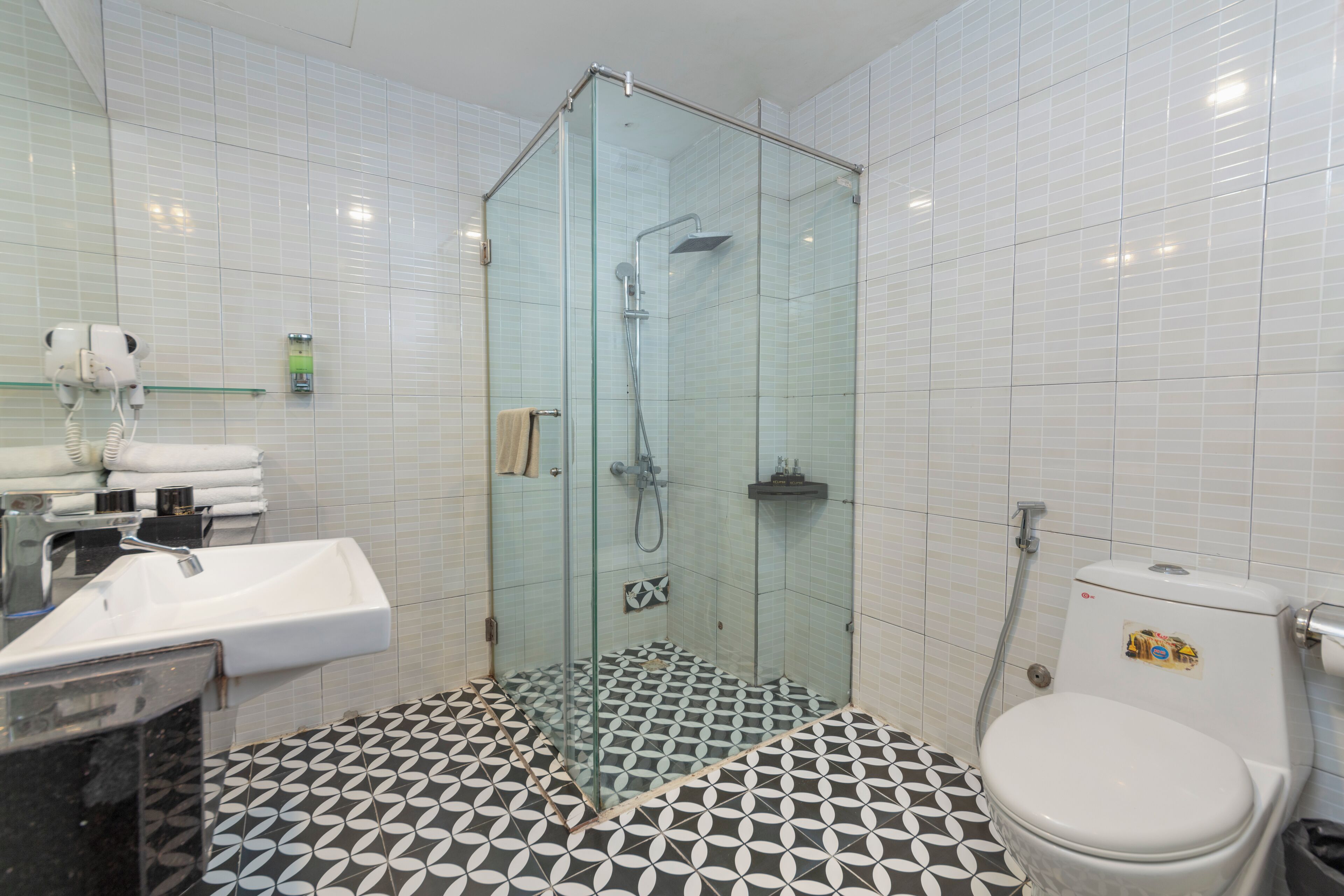 Et badeværelse med bruseniche, vask og toilet.