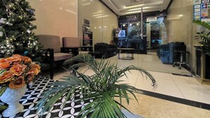 Eine moderne Lobby mit Weihnachtsbaum, Sitzgelegenheiten und einer Rezeption.