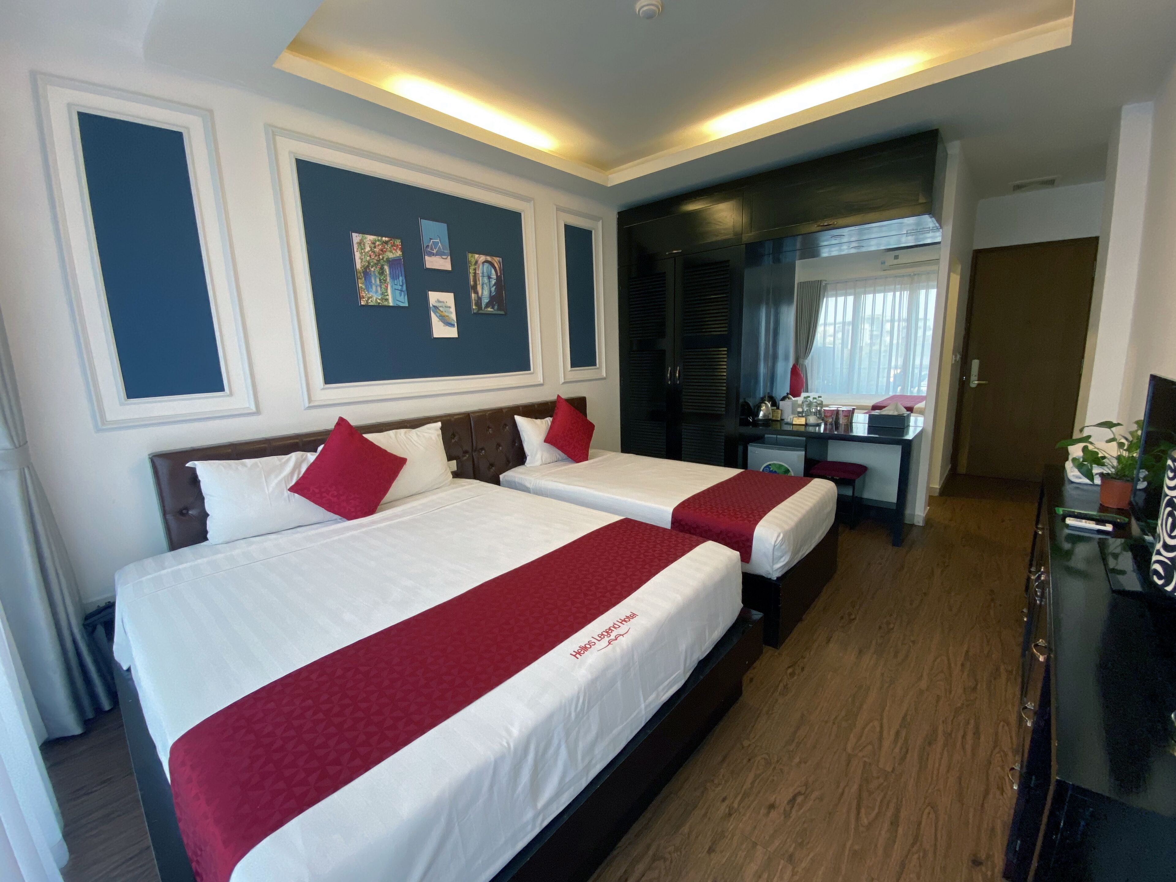 Een hotelkamer met twee bedden, een bureau en een spiegel.