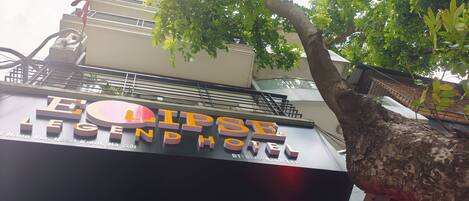 Une enseigne d’hôtel portant le nom « Eclipse Legend Hotel » et un numéro de téléphone.