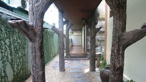 Un sentiero con paletti di legno e lastre di pietra che conduce all'ingresso di un edificio.