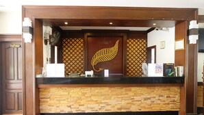 Una reception con finiture in legno, una decorazione a foglia di felce e una base in mosaico di pietra.