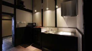 Una cocina moderna con pileta integrada, muebles de cocina negros y una campana extractora de acero inoxidable.