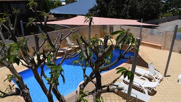 Alberca al aire libre y camastros