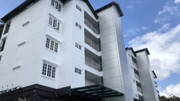 A multi-story building with a modern architectural design, featuring balconies and large windows.