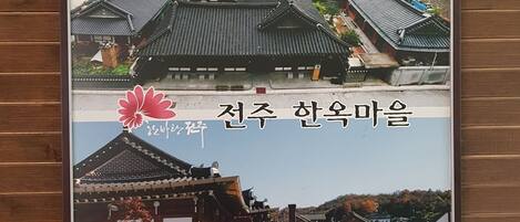 A traditional Korean building with a tiled roof and a wooden fence.