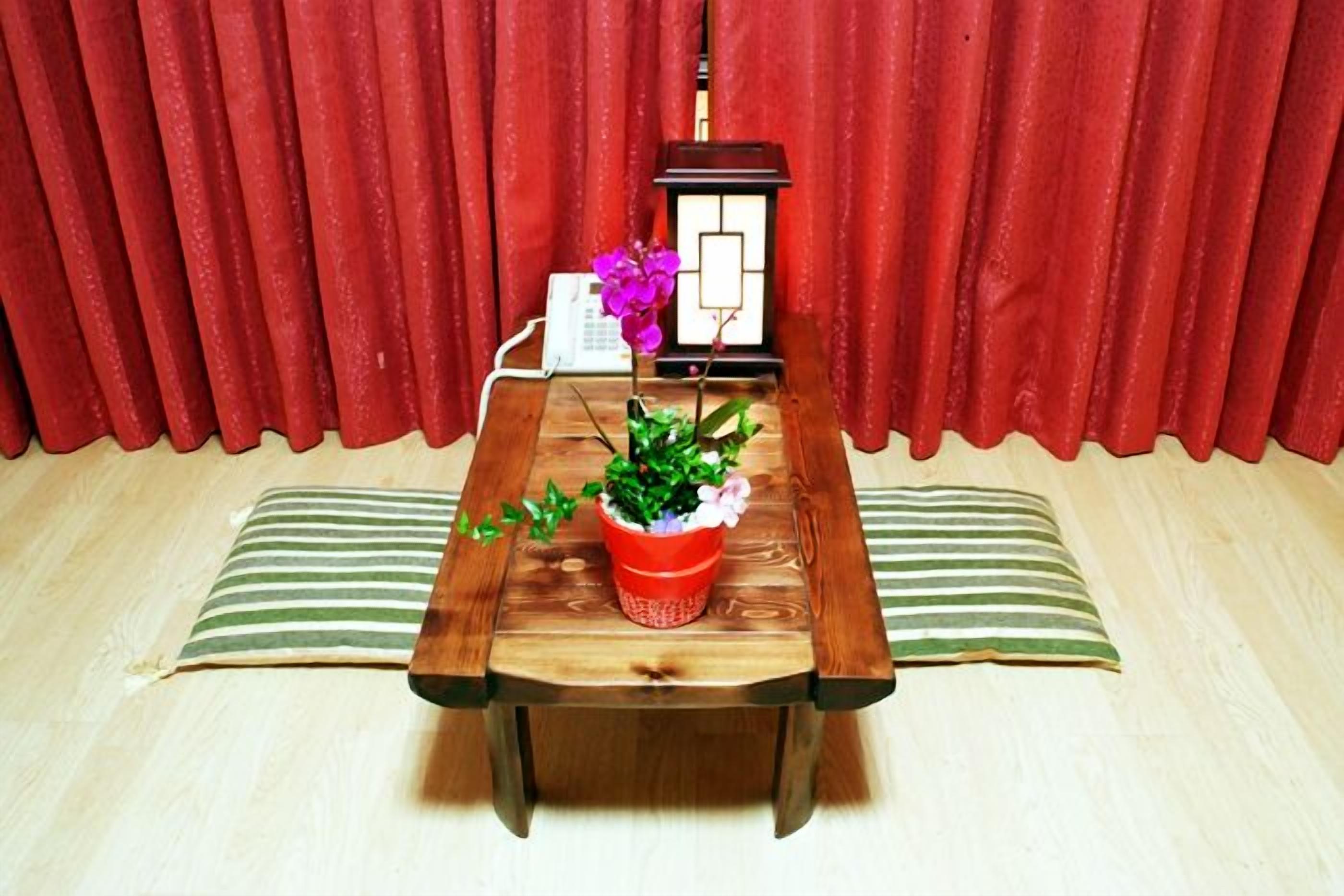 A wooden table with a potted plant and a lantern.
