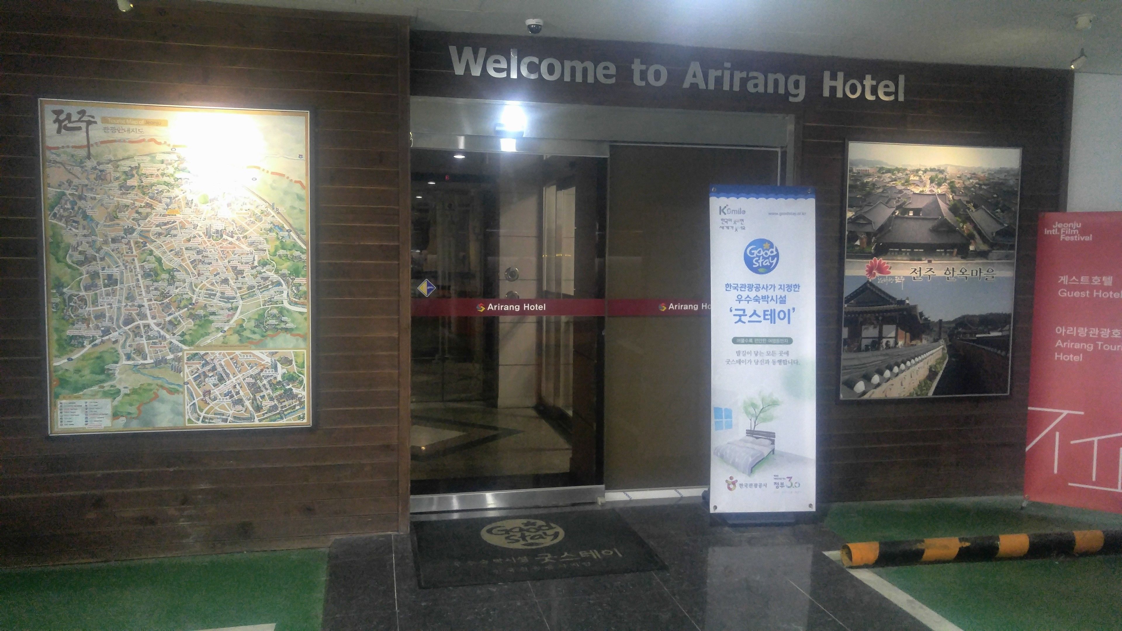 The entrance of Arirang Hotel with a welcome sign, a map, and a poster advertising a film festival.
