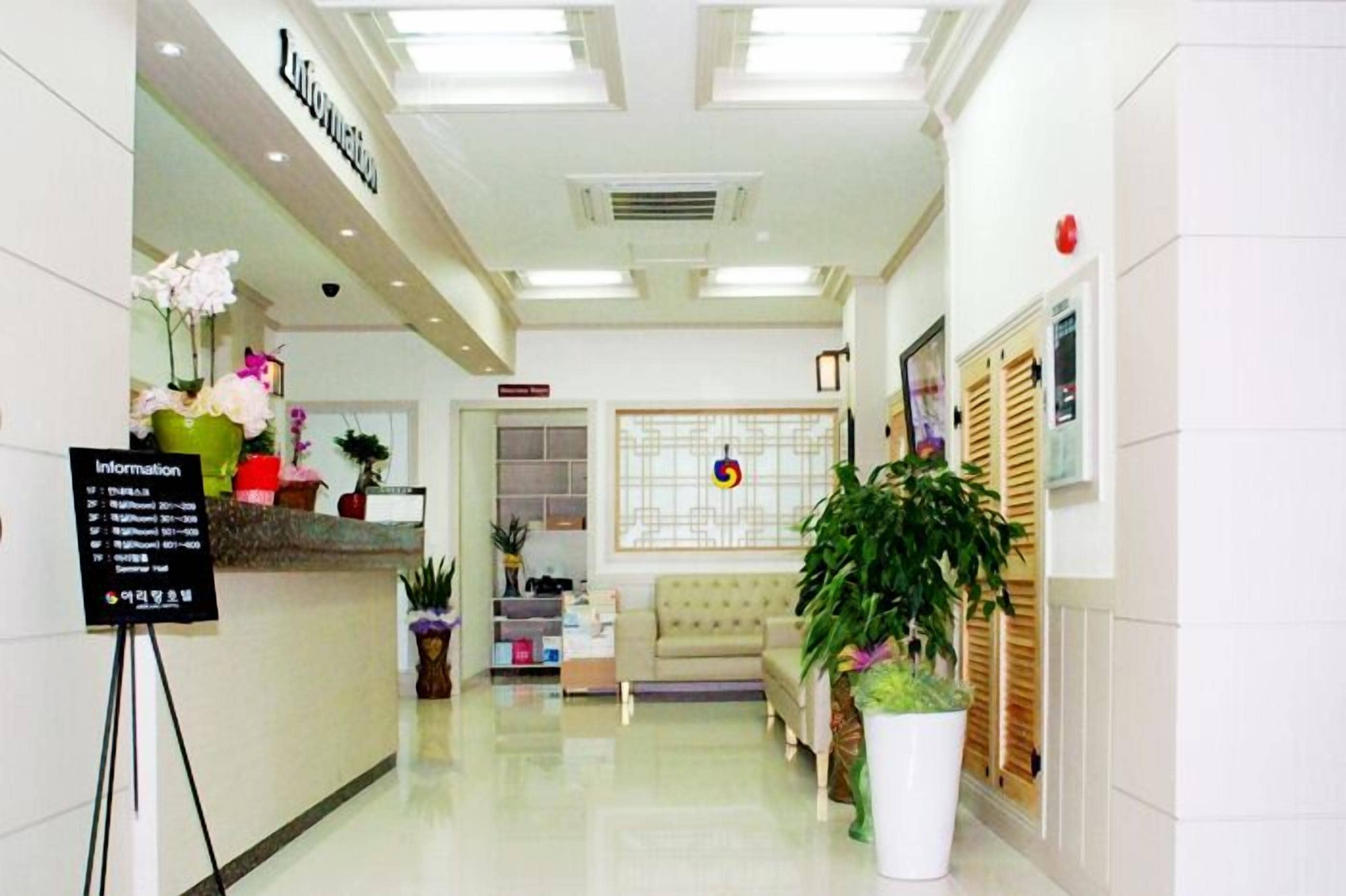 A clean, well-lit lobby with a reception desk, seating area, and decorative plants.