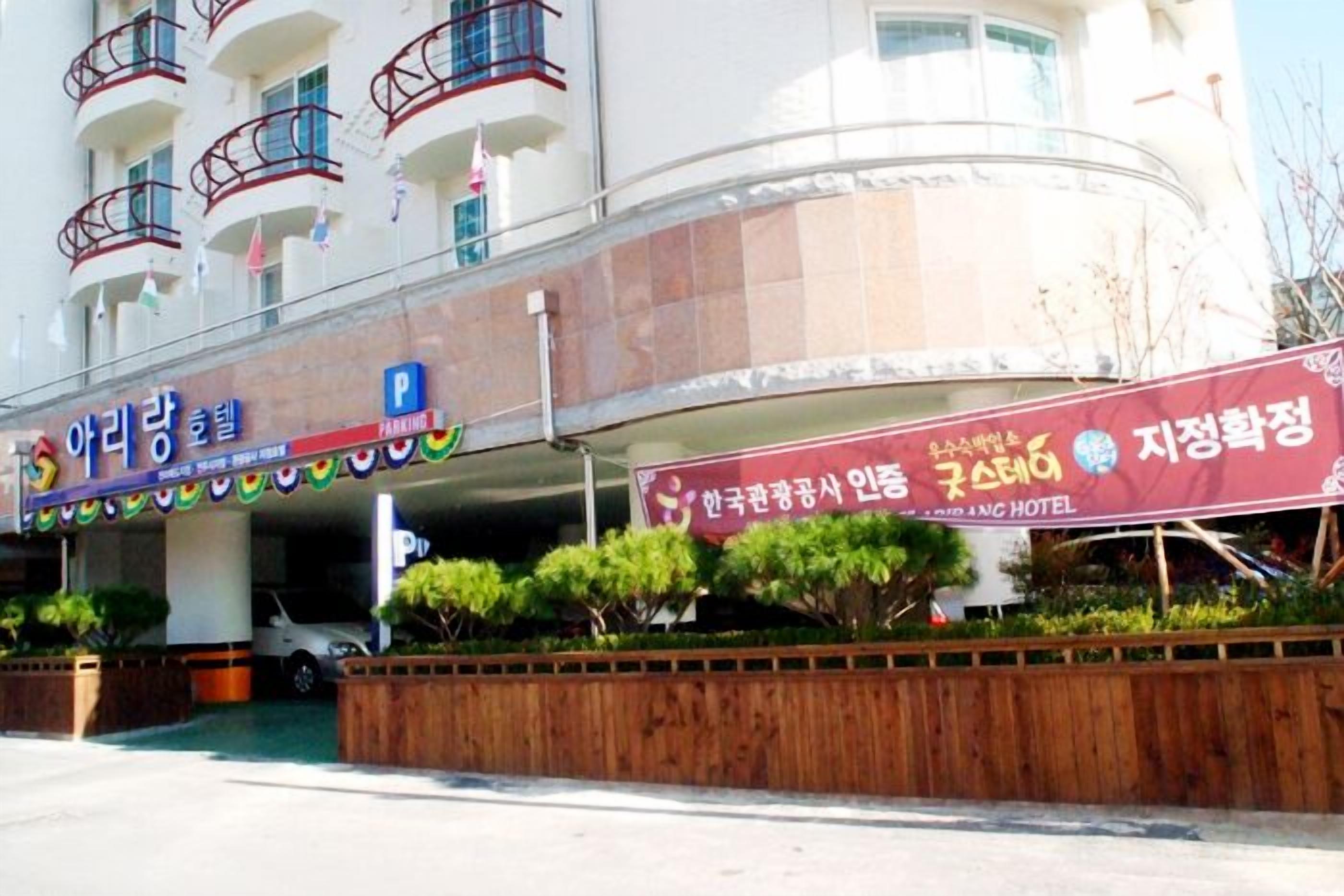 A hotel with a parking sign, a signboard for a restaurant, and a building with balconies.