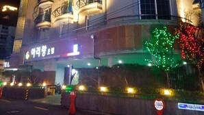 Un hotel a più piani con balconi, un neon e un albero di Natale.