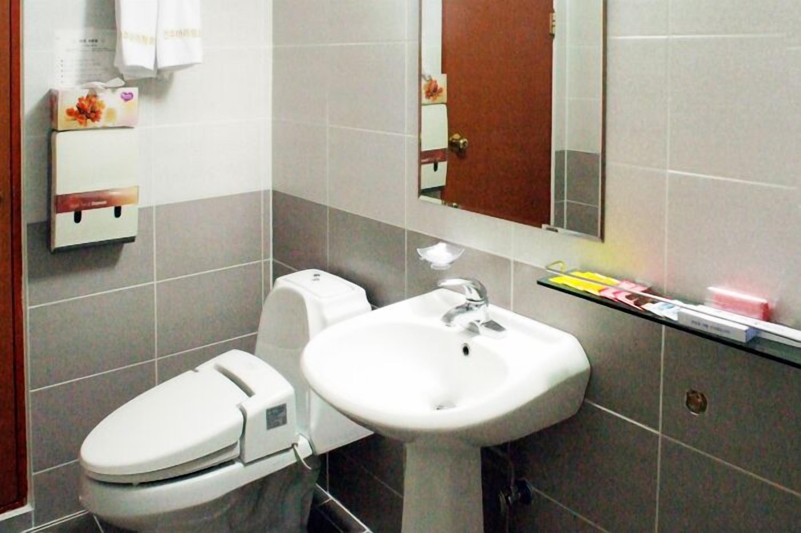Ein Badezimmer mit Toilette, Waschbecken und Spiegel.
