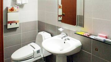 Ein Badezimmer mit Toilette, Waschbecken und Spiegel.