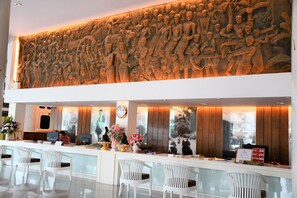 Welcome to our reception area, featuring a stunning bas-relief sculpture and modern design with a large window.