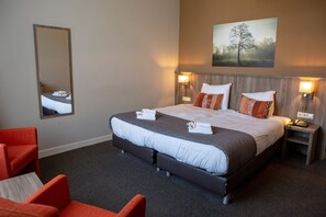 A hotel room with a large bed, two bedside tables, a nightstand, a chair, and a mirror. - Landgoed Hotel & Restaurant Carelshaven (Delden)