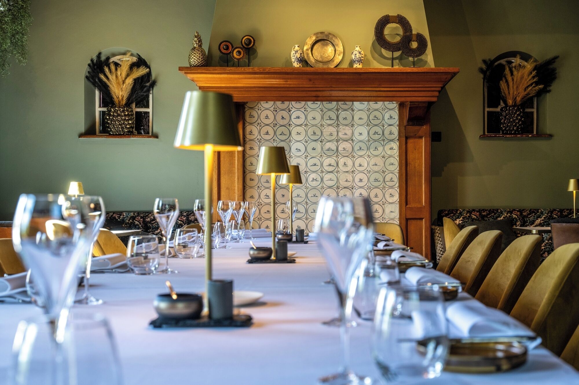 A dining area with a long table set for a meal, a fireplace, and decorative wall art.