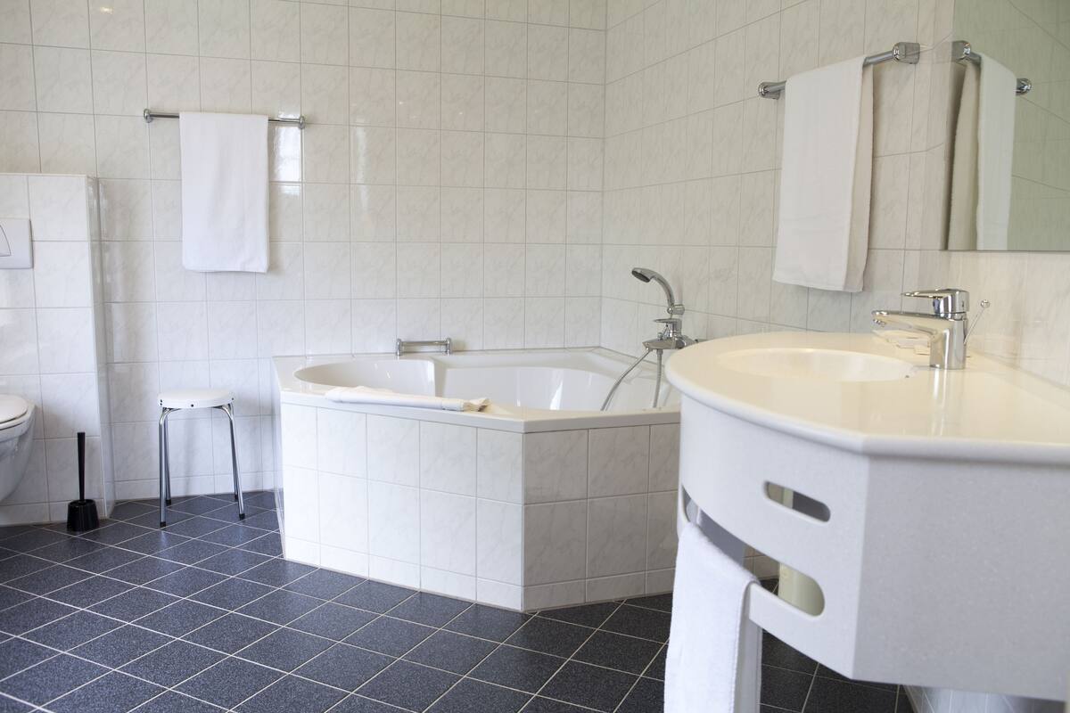 Un baño moderno con bañera, lavamanos e inodoro.
